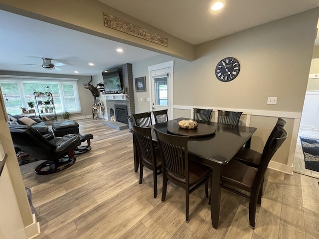 dining area with a fireplace, recessed lighting, light wood-style flooring, ceiling fan, and baseboards