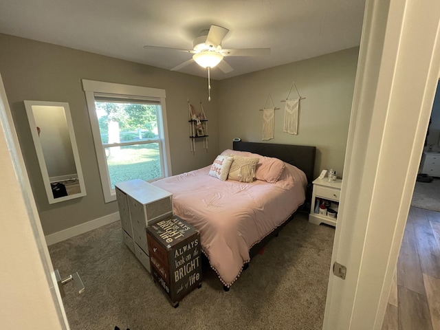 bedroom featuring a ceiling fan, baseboards, and wood finished floors