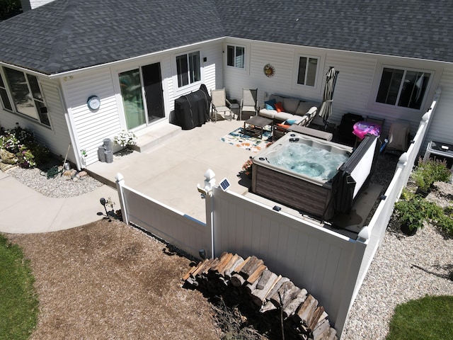 view of patio featuring entry steps, an outdoor hangout area, fence, and a hot tub