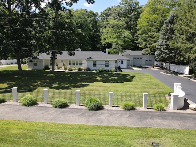 ranch-style home featuring a fenced front yard and a front lawn