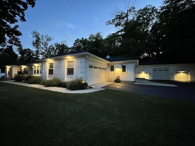 single story home featuring driveway, an attached garage, and a front yard