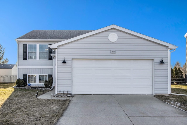 view of front of home featuring a garage, driveway, and roof with shingles