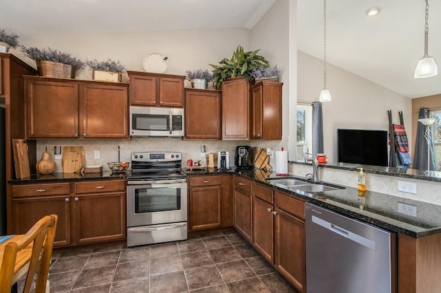 kitchen featuring lofted ceiling, backsplash, stainless steel appliances, and a sink