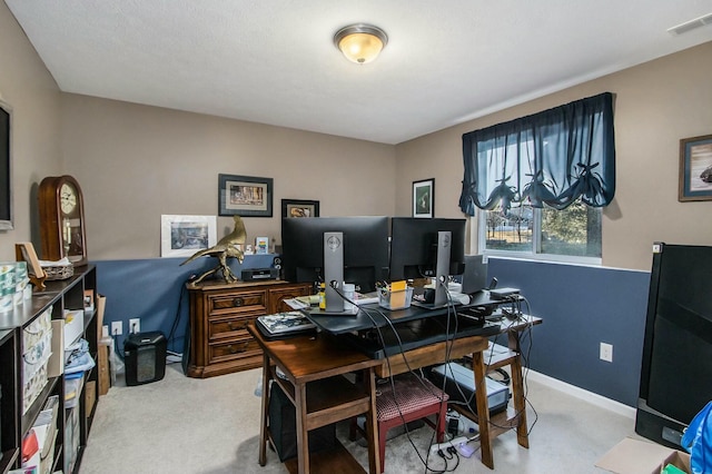 carpeted office space with baseboards and visible vents