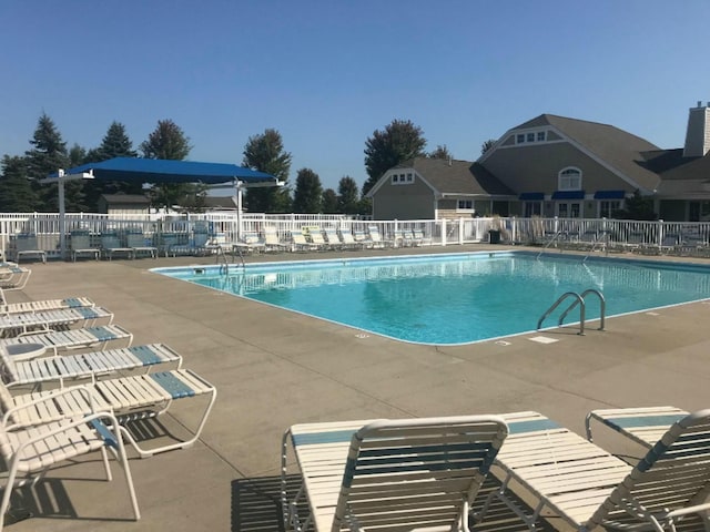 pool with a patio and fence