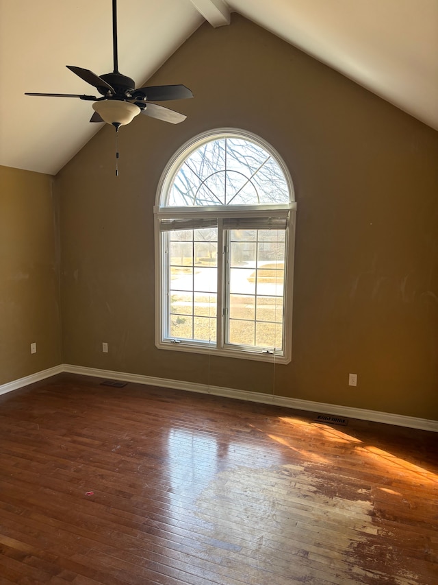 unfurnished room featuring dark wood-style floors, visible vents, beam ceiling, and baseboards