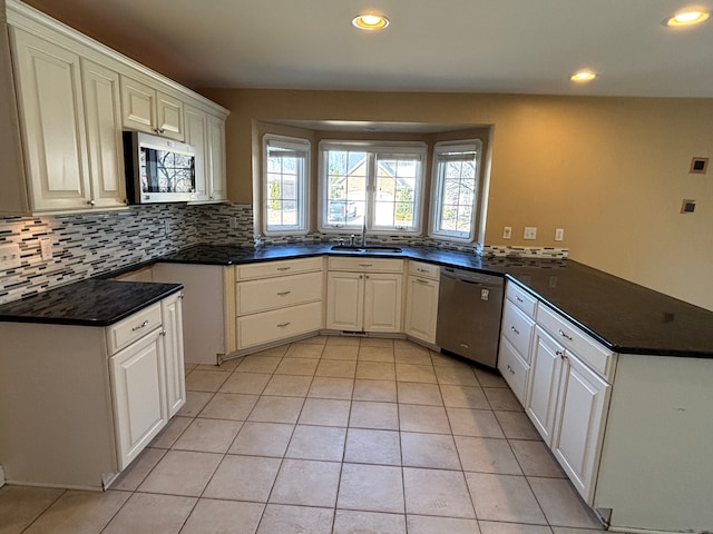 kitchen with a sink, tasteful backsplash, recessed lighting, appliances with stainless steel finishes, and a peninsula