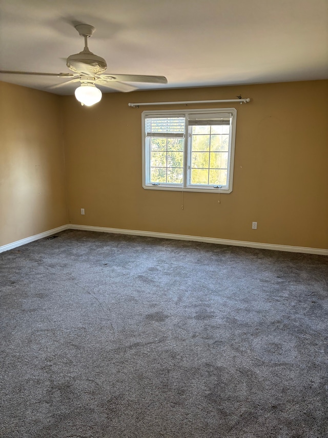 carpeted empty room featuring baseboards and ceiling fan