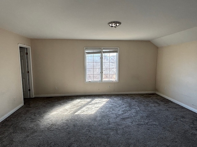 empty room with baseboards, carpet flooring, and vaulted ceiling