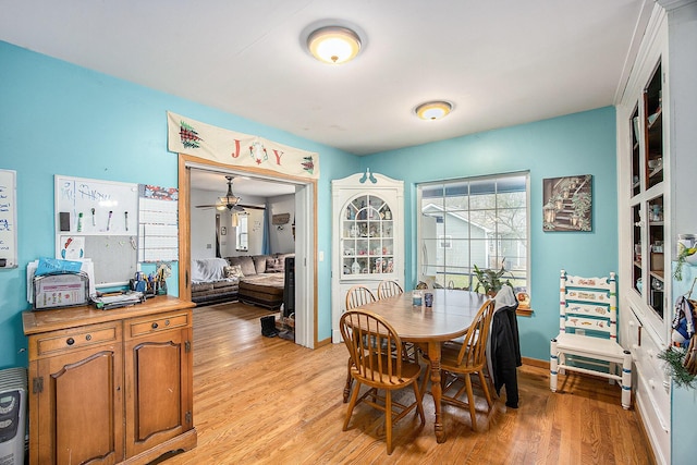 dining room featuring ceiling fan, light wood-style flooring, and baseboards