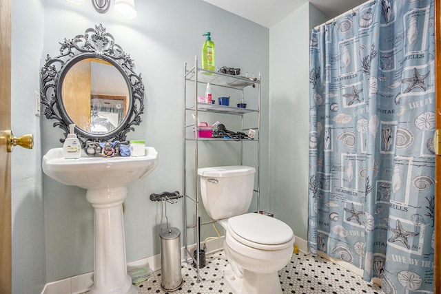 bathroom with toilet, baseboards, a shower with shower curtain, and tile patterned floors