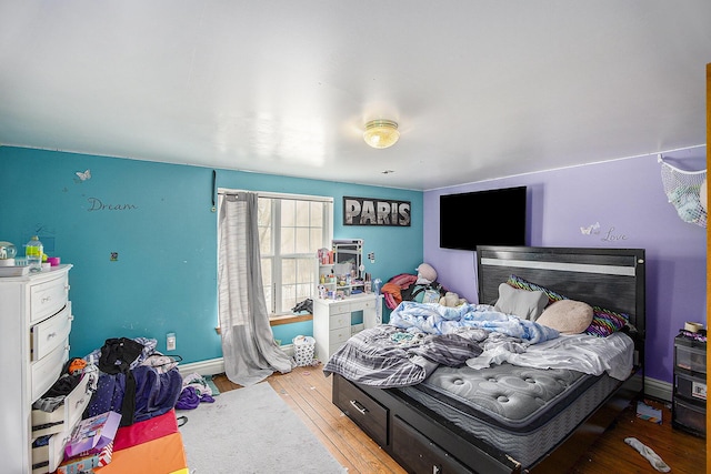 bedroom featuring baseboards and wood finished floors