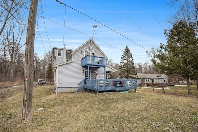 back of house featuring a yard and a balcony