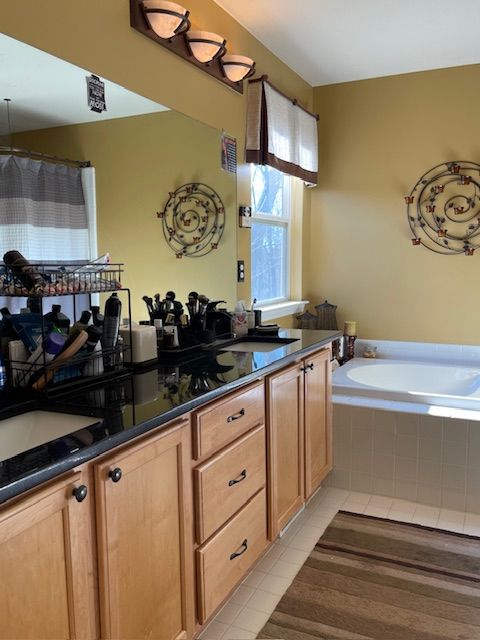 kitchen with a sink, dark countertops, and light tile patterned flooring