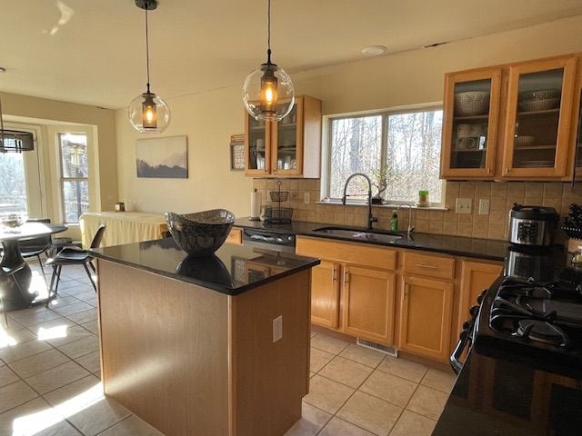 kitchen with plenty of natural light, a kitchen island, tasteful backsplash, and a sink