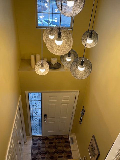 entryway with light tile patterned flooring and a towering ceiling