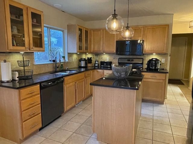 kitchen featuring light tile patterned floors, a kitchen island, black appliances, and a sink