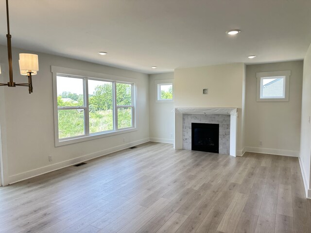 1846 Round Barn Dr, Hudsonville, MI 49426 - unfurnished living room with recessed lighting, wood finished floors, a fireplace, and a chandelier
