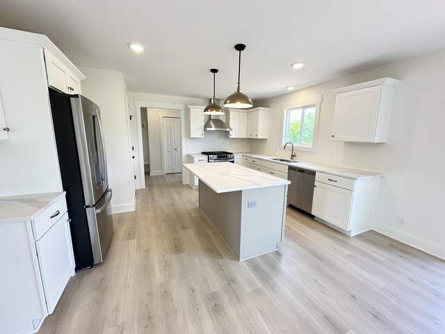1846 Round Barn Dr, Hudsonville, MI 49426 - kitchen featuring appliances with stainless steel finishes, wall chimney exhaust hood, white cabinets, a center island, and light wood-style floors