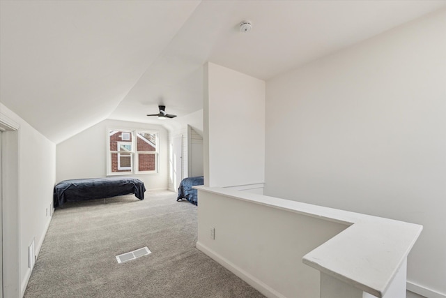 bedroom featuring carpet, visible vents, vaulted ceiling, and a ceiling fan