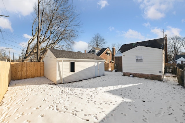 back of property with a storage shed, an outdoor structure, and a fenced backyard