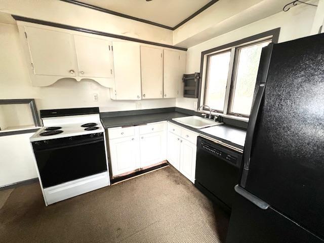 kitchen featuring white cabinets, dark countertops, crown molding, black appliances, and a sink