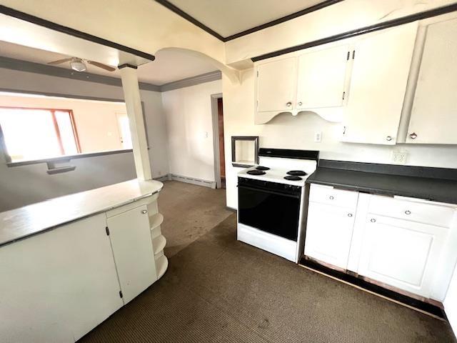 kitchen featuring arched walkways, ornamental molding, white cabinets, and electric range oven