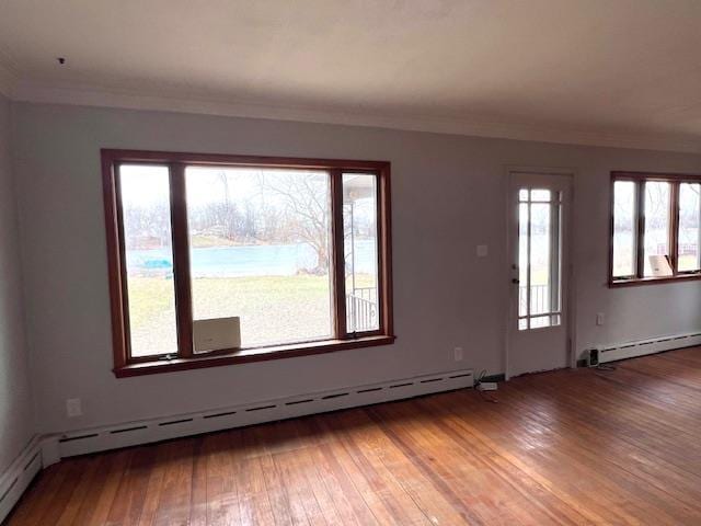 unfurnished room featuring wood-type flooring, ornamental molding, and baseboard heating