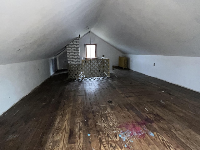 additional living space featuring lofted ceiling and hardwood / wood-style flooring