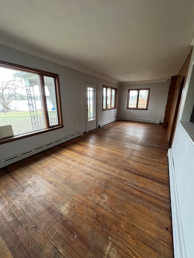 unfurnished living room featuring a baseboard heating unit, ornamental molding, and wood-type flooring