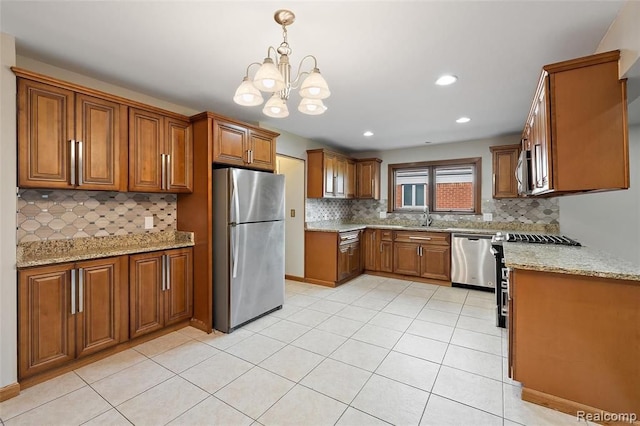 kitchen featuring appliances with stainless steel finishes, brown cabinets, a sink, and light stone countertops