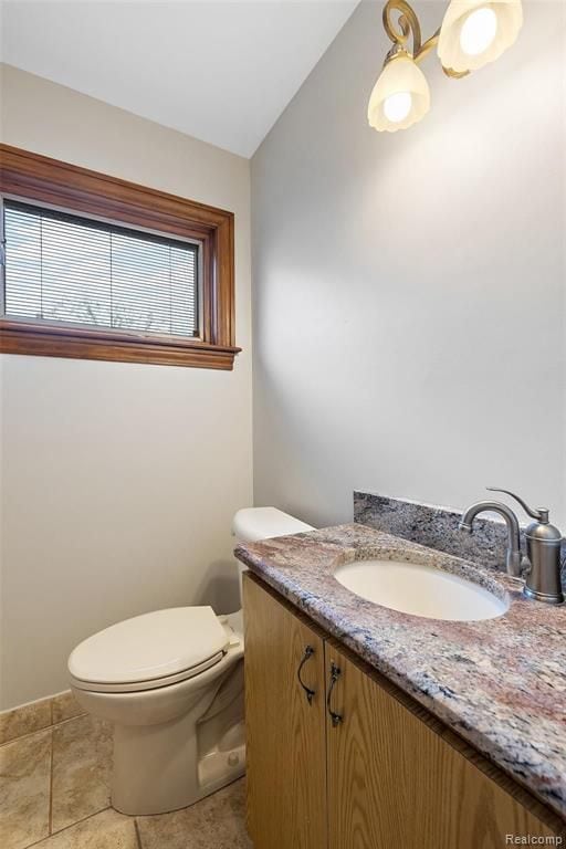 bathroom featuring toilet, vaulted ceiling, and vanity