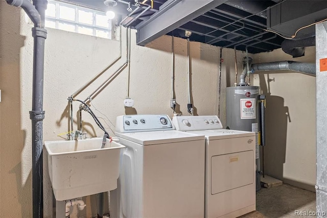 laundry room featuring a textured wall, washing machine and dryer, laundry area, a sink, and water heater