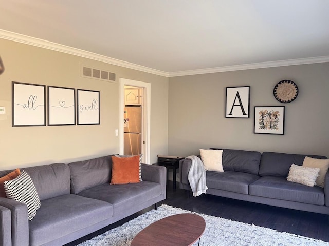 living room featuring ornamental molding, visible vents, and wood finished floors