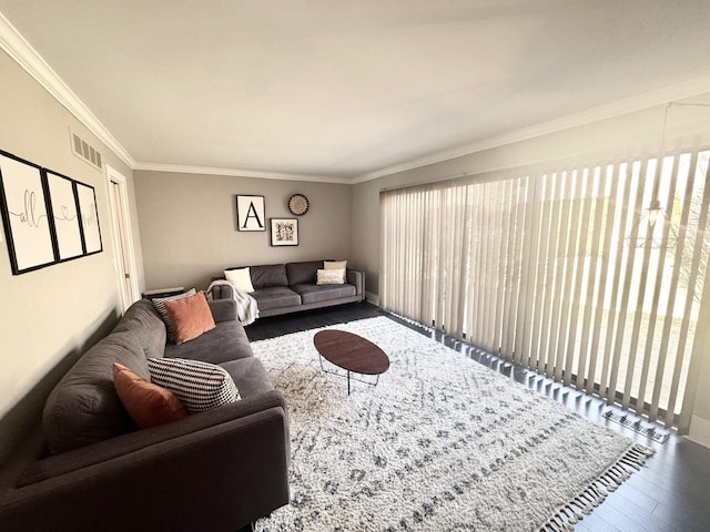 living room featuring visible vents, wood finished floors, a wealth of natural light, and ornamental molding