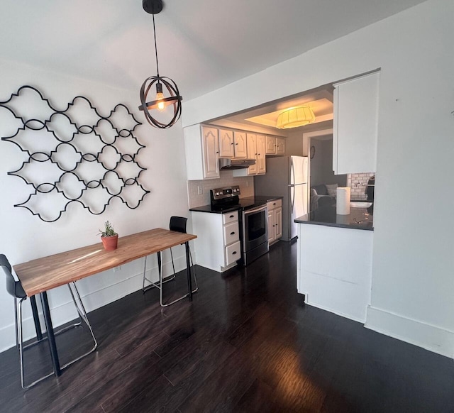 kitchen featuring stainless steel electric range, backsplash, dark wood-style floors, dark countertops, and a raised ceiling