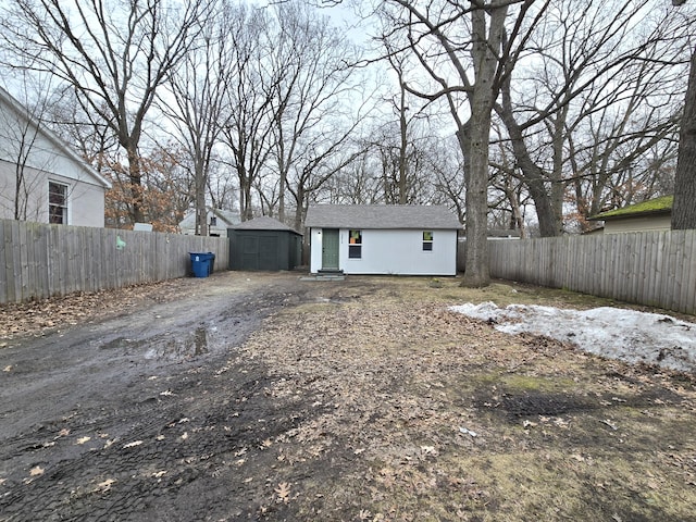 view of front of house with driveway, a fenced backyard, and an outdoor structure