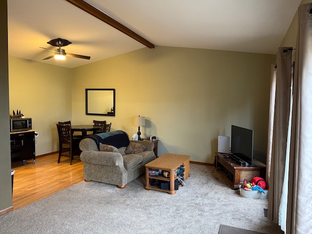 living room featuring vaulted ceiling with beams, ceiling fan, baseboards, and carpet flooring