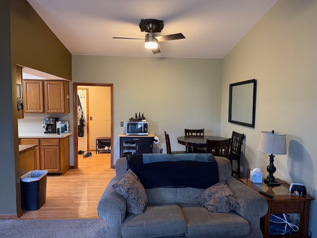 living area featuring light wood-type flooring and ceiling fan