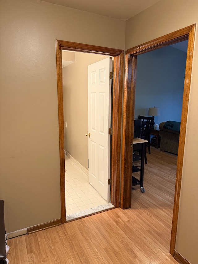 hallway featuring baseboards and light wood finished floors