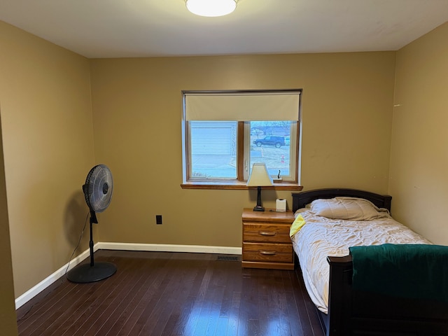 bedroom with dark wood finished floors and baseboards