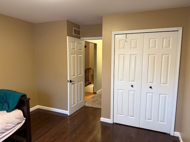 sitting room with dark wood-style floors, visible vents, and baseboards