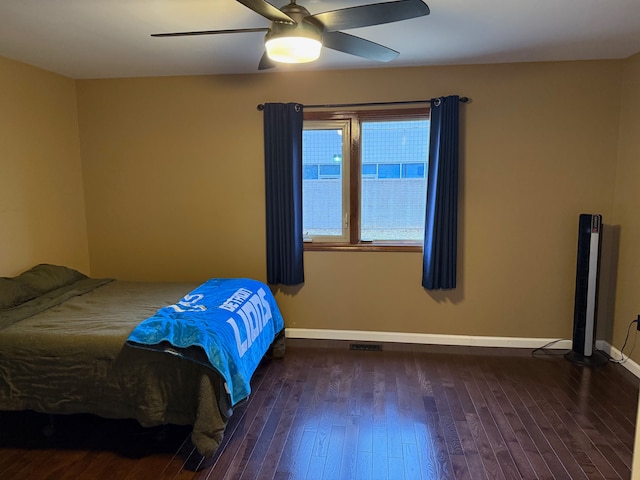 bedroom featuring a ceiling fan, wood-type flooring, visible vents, and baseboards