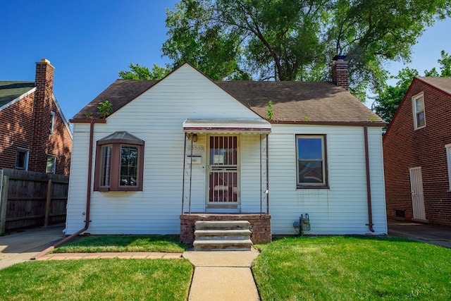 bungalow with a shingled roof, a chimney, a front yard, and fence