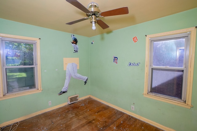 spare room featuring ceiling fan, hardwood / wood-style floors, and baseboards