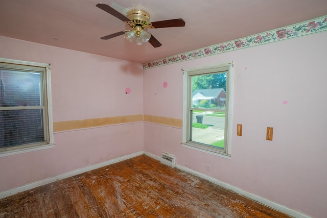 spare room featuring ceiling fan, baseboards, and wood finished floors