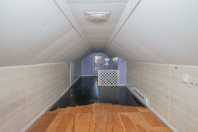 bonus room featuring a baseboard heating unit, vaulted ceiling, wood walls, and hardwood / wood-style floors