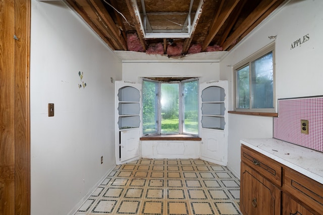 interior space with baseboards, decorative backsplash, and tile patterned floors