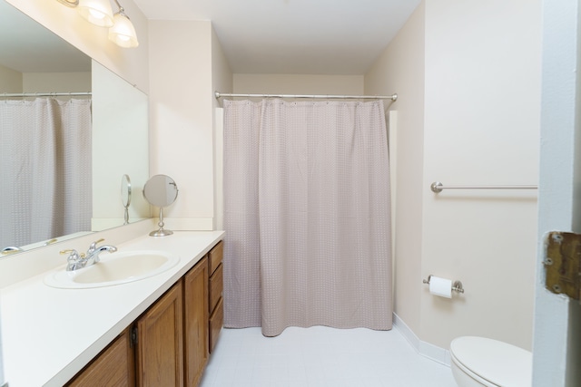 full bathroom featuring baseboards, toilet, and vanity