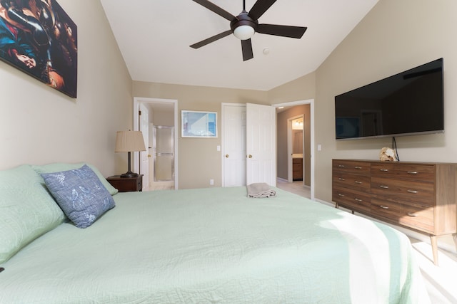 bedroom featuring ceiling fan, ensuite bath, and lofted ceiling